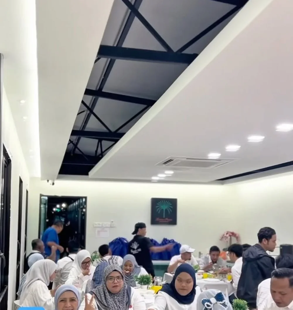 Ruang majlis berhawa dingin di tingkat atas penuh dengan tetamu, meja bertaplak putih.